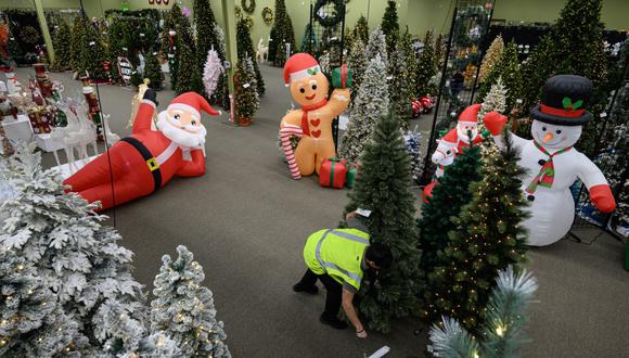 Un trabajador ajusta un árbol en una sala de exhibición de decoración navideña de National Tree Company en North Plainfield, Nueva Jersey, el 26 de octubre de 2022. (Foto de Ed JONES / AFP)