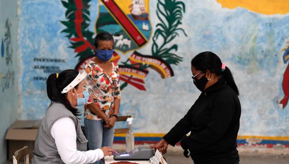 Una mujer con máscara vota en un colegio electoral de una escuela de Caracas, el 6 de diciembre de 2020 durante las elecciones legislativas de Venezuela. (Federico PARRA / AFP)