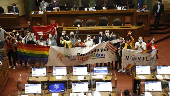 Integrantes de diferentes movimientos sociales celebran en el Senado tras la aprobación de un proyecto de ley para legalizar el matrimonio entre personas del mismo sexo en Chile, en el Congreso Nacional en Valparaíso, Chile, el 7 de diciembre de 2021. (Foto de Dedvi MISSENE / AFP)