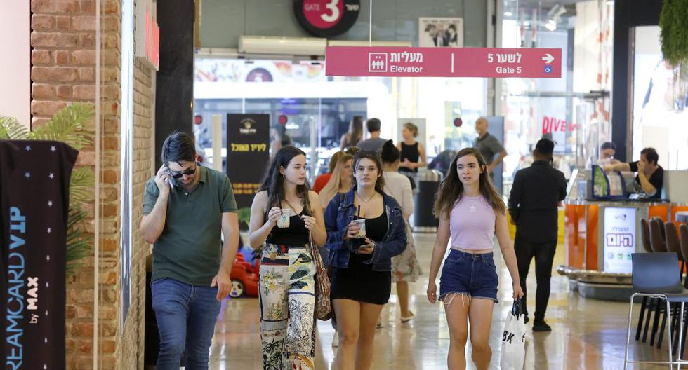 Los compradores sin máscara caminan en el centro comercial Dizengoff en la ciudad costera israelí de Tel Aviv, el 15 de junio de 2021. (JACK GUEZ / AFP).
