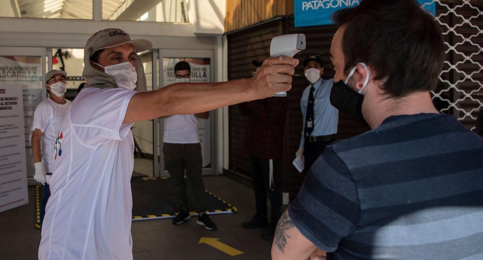 Un trabajador de seguridad verifica la temperatura a un cliente durante la reapertura de un centro comercial como medida preventiva por el coronavirus, en Santiago el 30 de abril de 2020. Foto: AFP / Martin BERNETTI