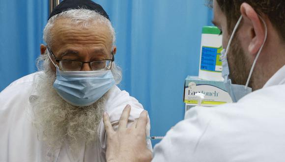 Un trabajador de la salud administra una vacuna contra el coronavirus COVID-19 a un anciano en la ciudad ultraortodoxa de Bnei Brak, Israel, el 6 de enero de 2021. (Foto de JACK GUEZ / AFP).