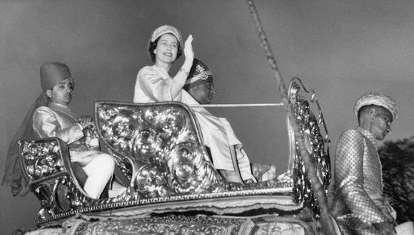 La reina Isabel II de Gran Bretaña saluda a la multitud mientras monta un elefante junto al maharajá de Jaipur Man Singh II en el Palacio de la ciudad de Jaipur el 24 de enero de 1961. (Foto de PRENSA CENTRAL / AFP)