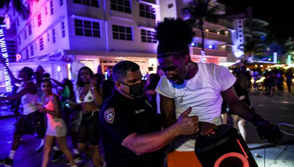 La policía de Miami Beach detiene a un hombre que lleva un parlante inalámbrico en Ocean Drive. (Foto de CHANDAN KHANNA / AFP).