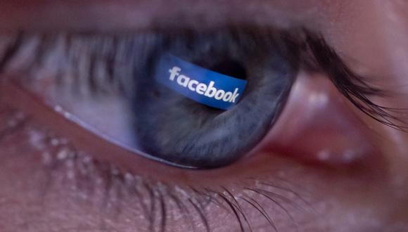 Una persona posando durante una sesión de fotos que muestra el logotipo de la plataforma social Facebook reflejado en la pupila de un ojo. (Foto:  Christophe SIMON / AFP)