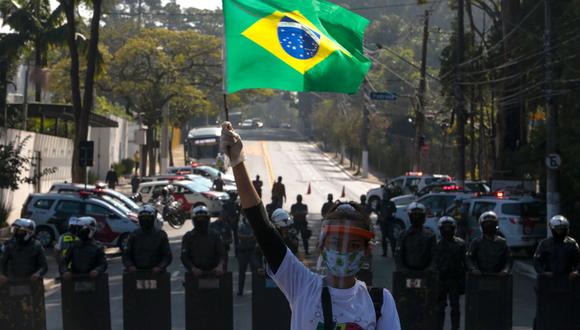 Un residente de Paraisópolis, uno de los barrios marginales más grandes de la ciudad, participa en una protesta en Sao Paulo, Brasil, el 18 de mayo de 2020, para exigir más ayuda del gobierno del estado de Sao Paulo durante la pandemia de coronavirus COVID-19. (AFP / Miguel SCHINCARIOL).