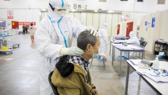 En la imagen se observa a un miembro del personal médico haciendo un masaje a un paciente que ha mostrado síntomas leves del coronavirus COVID-19 en Wuhan. (Archivo / AFP)