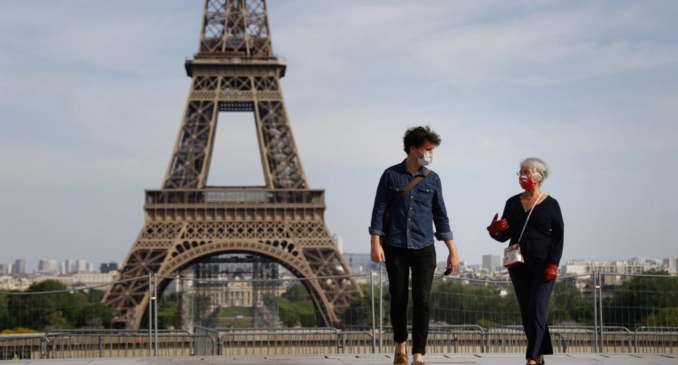 Imagen referencial. Las personas que usan una mascarilla por el coronavirus caminan cerca de la Torre Eiffel en París (Francia), el 20 de abril de 2020. (THOMAS COEX / AFP).