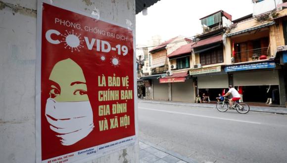 Un cartel propagandístico sobre la prevención de la propagación del coronavirus en la pared de una calle en Hanoi, Vietnam.