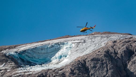 Un helicóptero de rescate vuela el 4 de julio de 2022 sobre el glaciar que se derrumbó el día anterior en la montaña de Marmolada, la más alta de los Dolomitas, un día después de que se registrara una temperatura récord de 10 grados Celsius (50 grados Fahrenheit) en el cumbre del glaciar. - Los equipos de rescate reanudaron hoy la búsqueda de sobrevivientes después de que una avalancha provocada por el derrumbe del glaciar, el más grande de los Alpes italianos, mató al menos a seis personas e hirió a otras ocho. (Foto de Pierre TEYSSOT / AFP)
