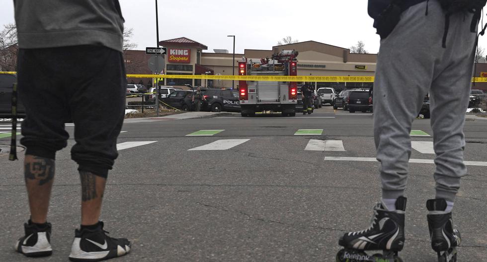 Los espectadores se paran afuera de la tienda de comestibles King Soopers en Boulder, Colorado, el 22 de marzo de 2021 después de los informes de un tirador activo. (Jason Connolly / AFP).