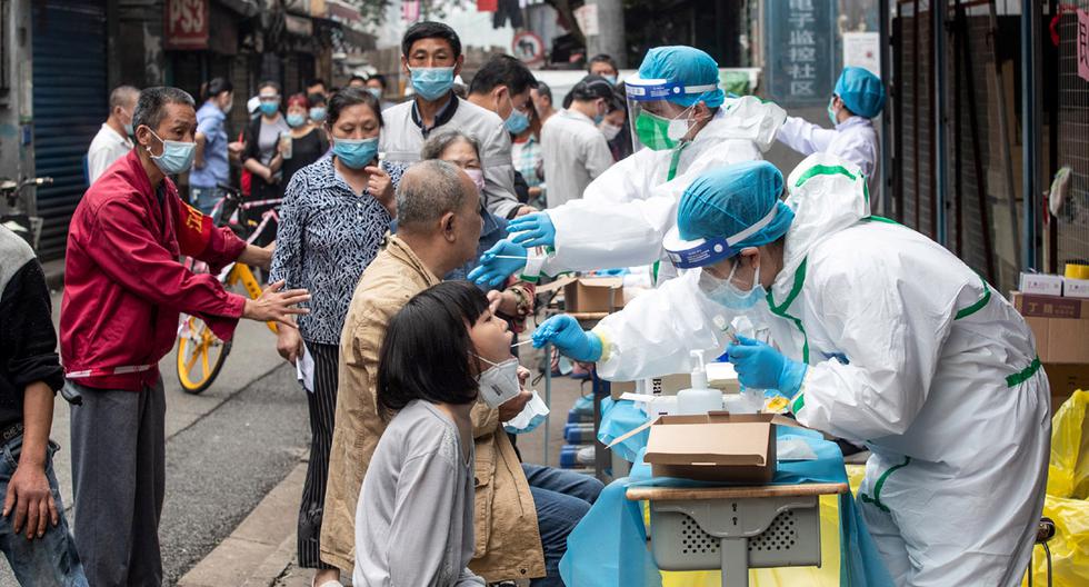 Imagen referencial. Los trabajadores médicos toman muestras de los residentes para analizar el coronavirus (COVID-19) en una calle de Wuhan. (Foto: AFP/STR)