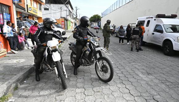 Soldados y policías escoltan a un preso (de naranja) a la corte, afuera de la prisión Pichincha 1 en Quito el 8 de noviembre de 2022, un día después de que cinco reclusos murieran en enfrentamientos entre bandas rivales. (Foto de Rodrigo BUENDIA / AFP)