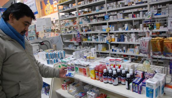 Un hombre mirando qué medicinas comprar en una farmacia.