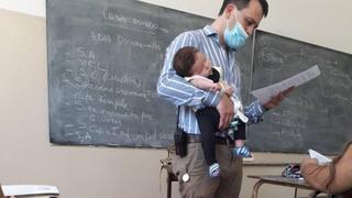Joven asiste a clases con su bebé y profesor la sostiene para que no se desconcentre