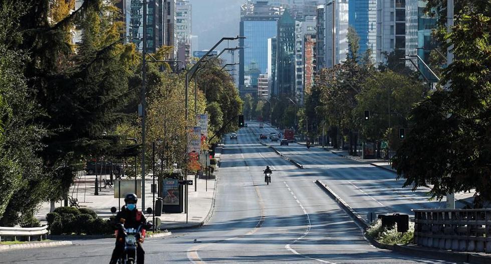 Un motociclista transita el 27 de marzo de 2021 por una avenida casi vacía durante la cuarentena obligatoria decretada en Chile ante el avance de la pandemia de coronavirus covid-19. (EFE/Alberto Valdés).