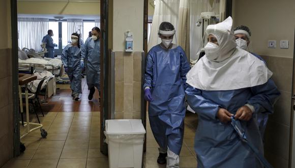 Los trabajadores médicos israelíes atienden a pacientes infectados por el coronavirus, en una sala de aislamiento en el Centro Médico Ziv en la ciudad de Safed, en el norte de Israel, el 6 de febrero de 2022. (Foto: JALAA MAREY / AFP)