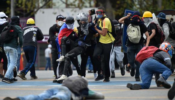 Un hombre ayudado por compañeros manifestantes luego de ser alcanzado por una bala durante enfrentamientos con la policía en el marco de una nueva protesta contra el gobierno del presidente colombiano Iván Duque, en Cali, Colombia, el 28 de mayo de 2021. (Luis ROBAYO / AFP).