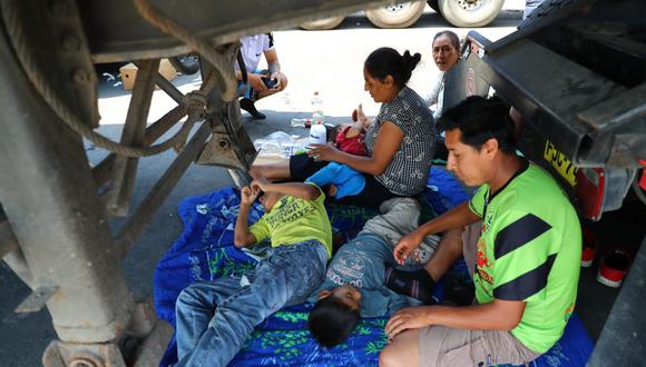 Niños descansando debajo de un bus de transporte pesado que está varado en plena carretera de Ica. | Foto: Alessandro Currarino / @photo.gec
