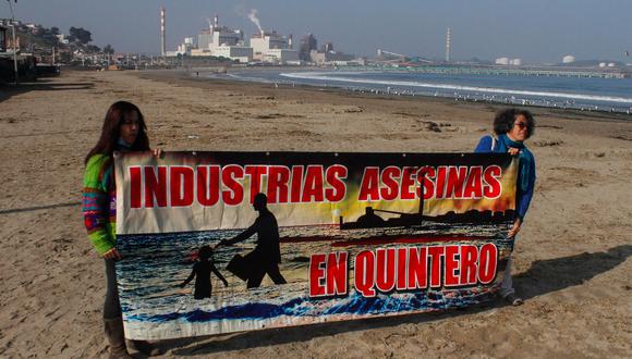 Dos personas sostienen un cartel durante una manifestación en distintos lugares de la Bahía de Quineros-Puchuncaví para exigir medidas contra la industria después un caso de contaminación, hoy en Valparaiso (Chile). (Foto: EFE/ Cristobal Basaure)