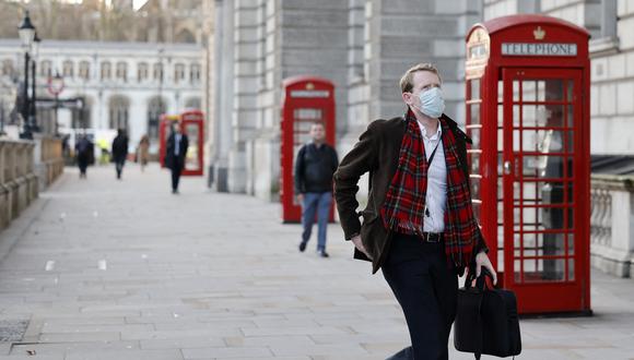 Un hombre que se cubre la cara para mitigar la propagación de Covid-19 camina por Whitehall en el centro de Londres el 5 de enero de 2022. (Foto: Tolga Akmen / AFP)