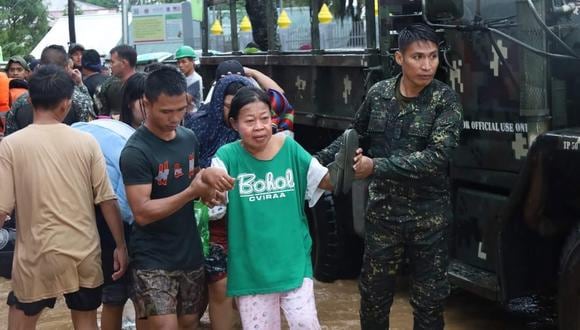Esta imagen muestra a policías ayudando a una mujer  durante una operación de rescate en la ciudad de Parang, Maguindanao, Filipinas. (Foto: EFE/EPA/BAPRO)
