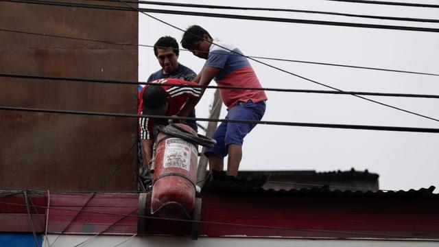 Ciudadanos cargando un extintor para apoyar a sofocar las llamas. Foto: Ángela Ponce