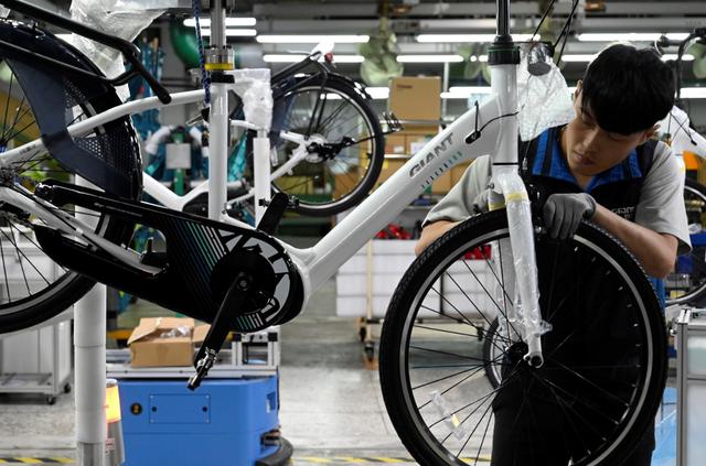 Esta imagen de archivo muestra a un trabajador revisando una bicicleta eléctrica en una fábrica de Giant, el mayor fabricante de bicicletas del mundo, en Taichung. (Sam YEH / AFP)