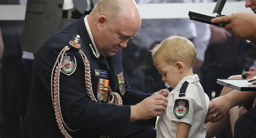 Niño recibe medalla en honor a su padre, quien murió apagando los incendios en Australia. Foto: AFP