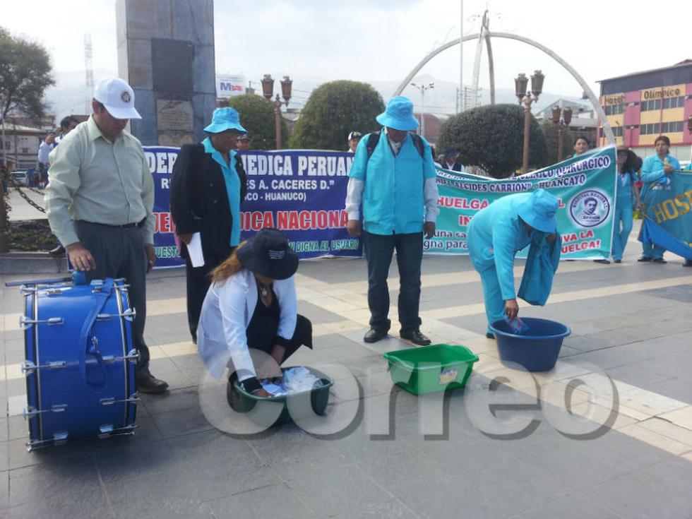 Médicos y enfermeras lavan mandiles y bandera 