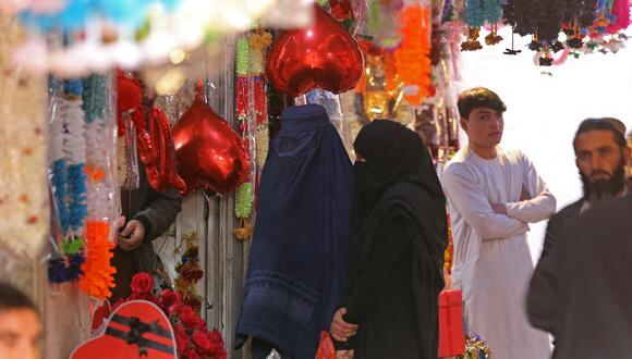 Mujeres afganas vestidas con burka compran regalos en una tienda con motivo del Día de San Valentín en Jalalabad el 14 de febrero de 2023. (Foto de Shafiullah KAKAR / AFP)