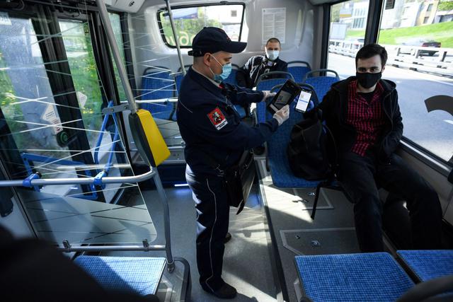 Un inspector revisa los documentos de un hombre que viajaba en un autobús eléctrico el primer día de uso obligatorio de máscaras y guantes en el transporte público de Moscú, en Moscú el 12 de mayo de 2020, en medio de la pandemia de coronavirus. (Foto: AFP/Kirill Kudryavtsev)
