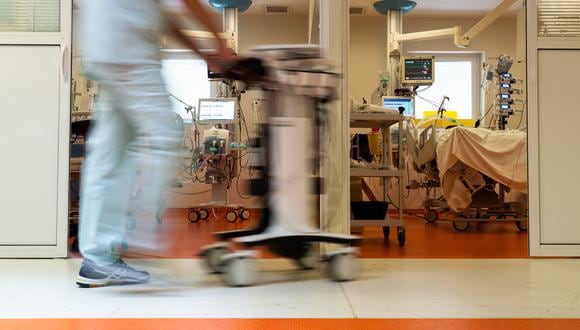Un miembro del personal médico pasa junto a la habitación de un paciente de Covid-19, en la unidad de cuidados intensivos. (Foto: Carla BERNHARDT / AFP)