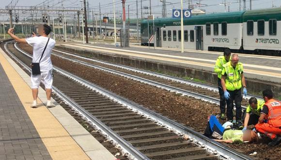 Joven causa polémica al tomarse selfie mientras rescatan a mujer herida en vías de tren