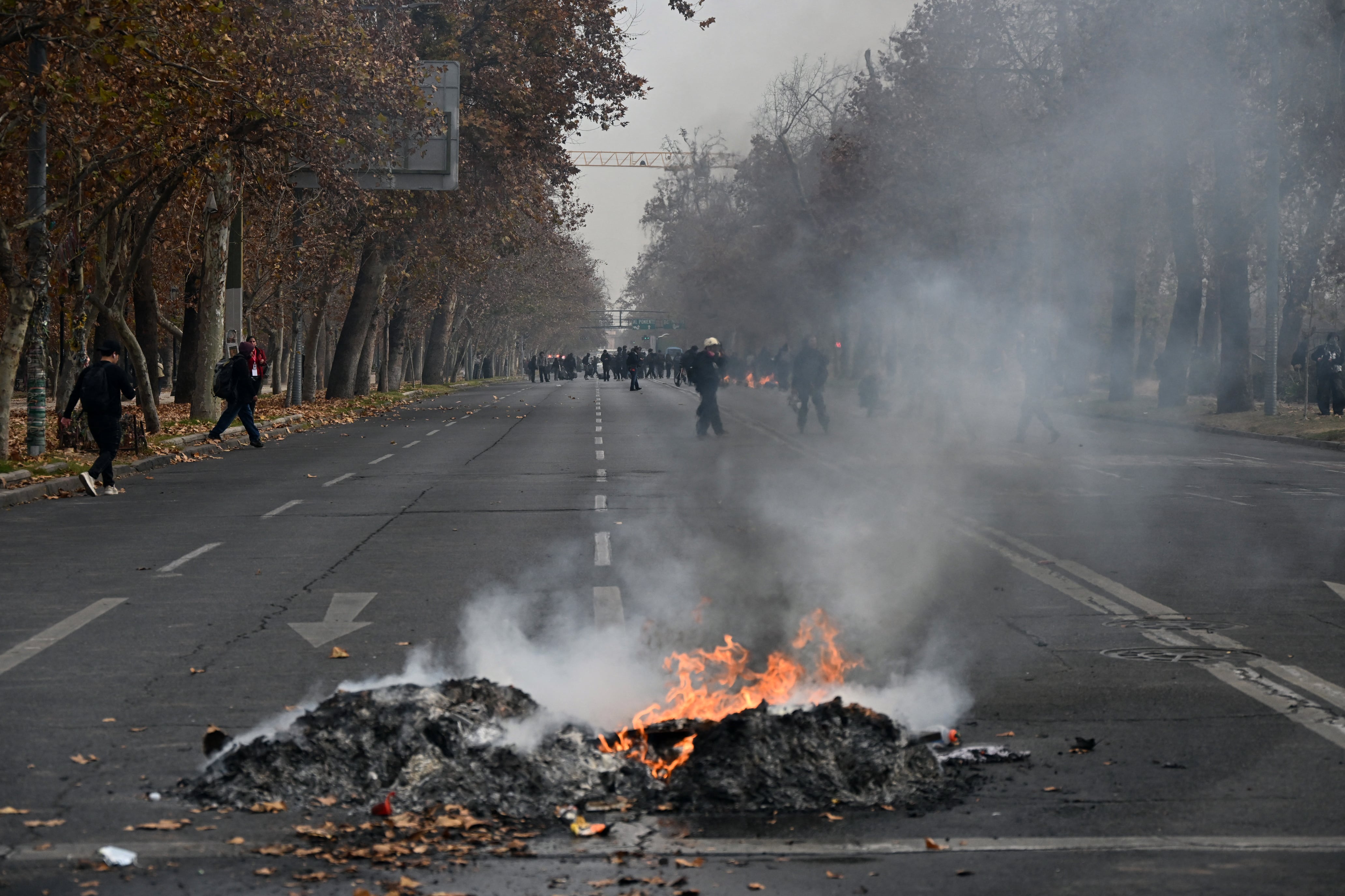 View of a fire set up by demonstrators following a students march against social cuts pushed through by Chile's President Jose Antonio Kast in Santiago, on June 3, 2026. (Photo by RODRIGO ARANGUA / AFP)