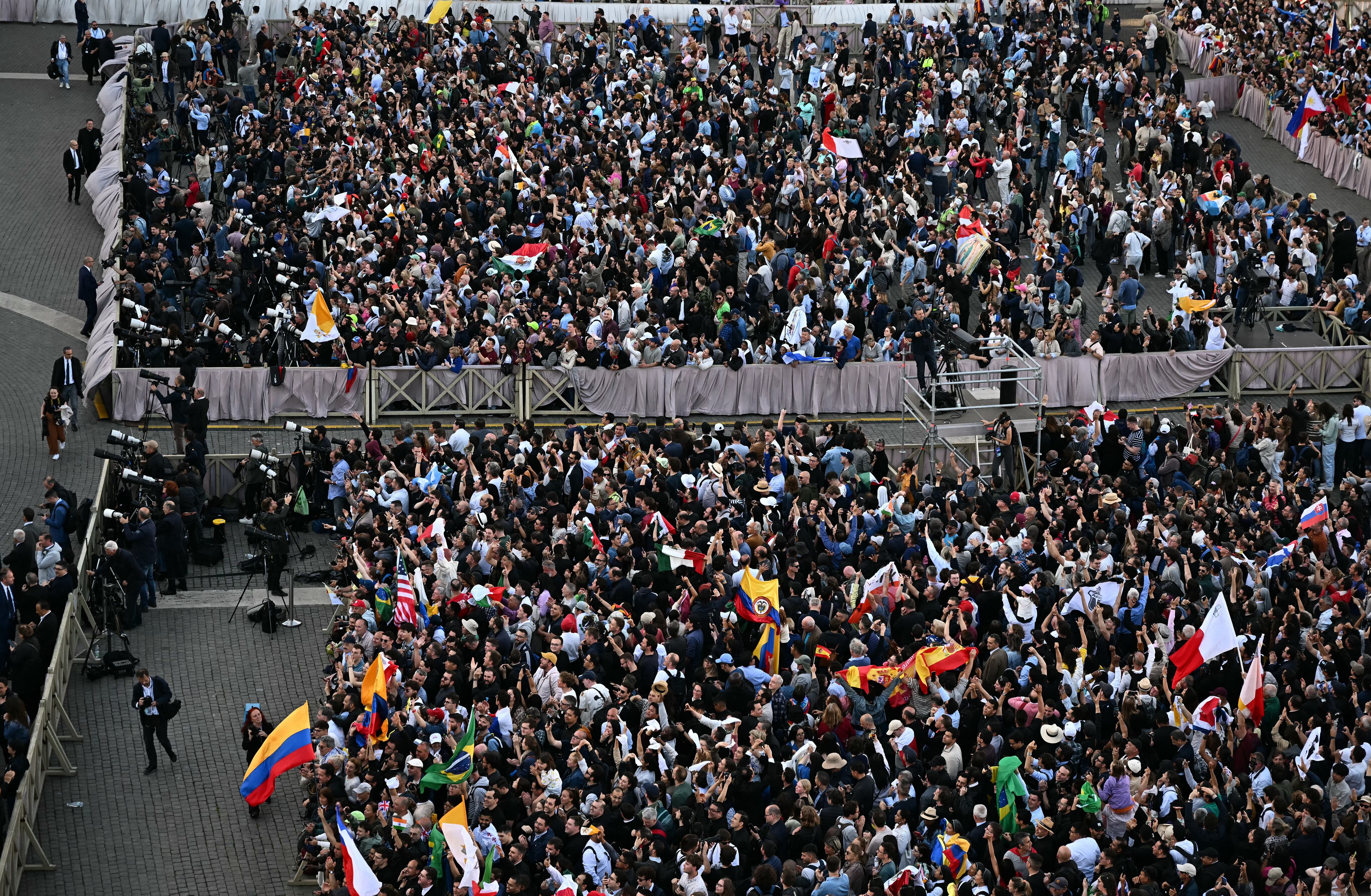 People react at St Peter's Square as the cardinals signaled they elected a new pope during their secret conclave, in The Vatican, on May 8, 2025. White smoke billowed from the chimney atop the Vatican's Sistine Chapel on Thursday, signalling that the 133 cardinals inside have elected a new pope. (Photo by Gabriel BOUYS / AFP)