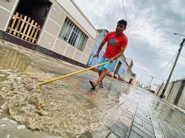 Con escobas retiran el agua de las pistas. (Foto: Randy Reyes)