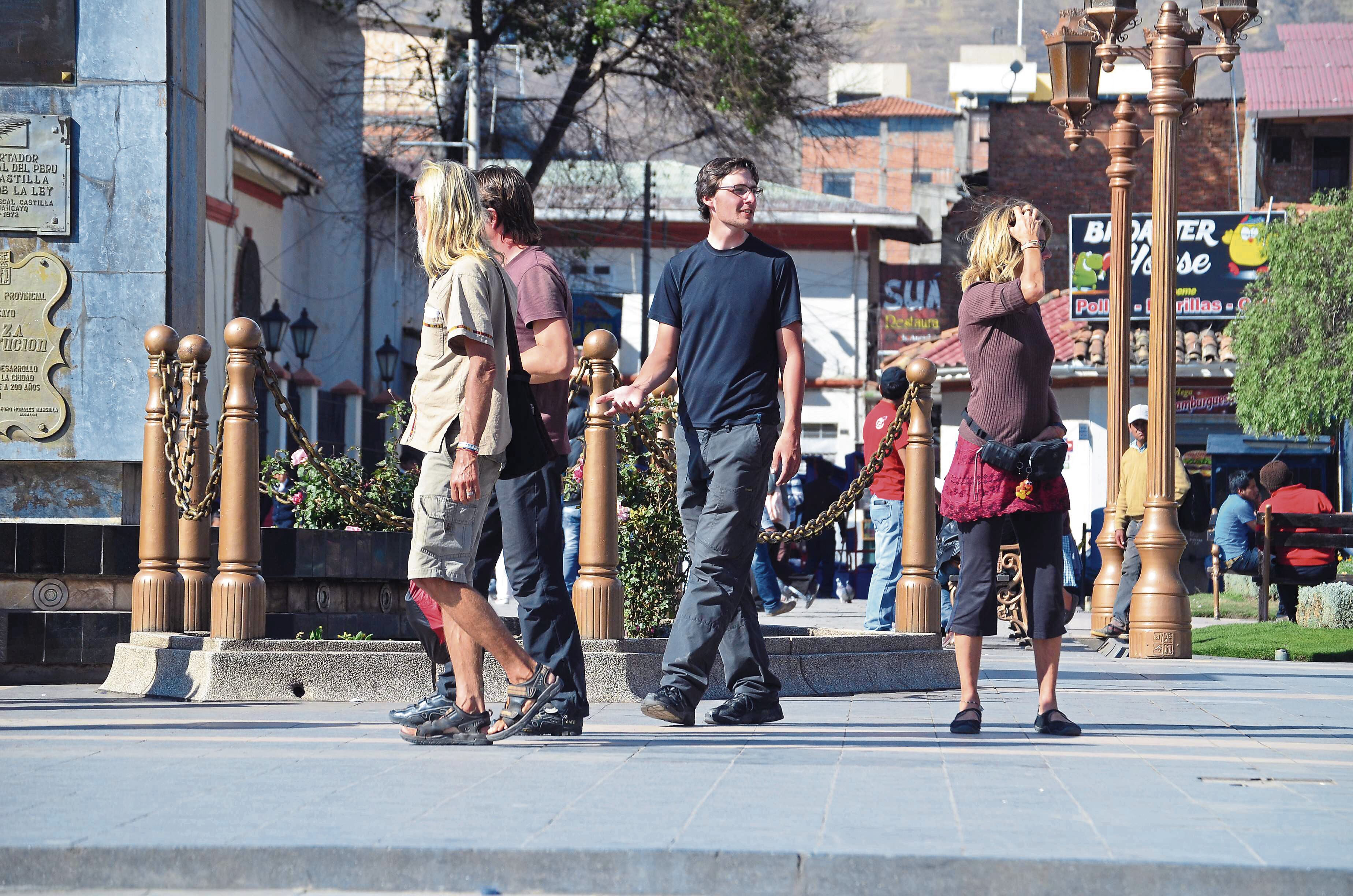 GRUPO DE TURISTAS SE PASEAN POR LA PLAZA CONSTITUCION EN DIA DE CALOR