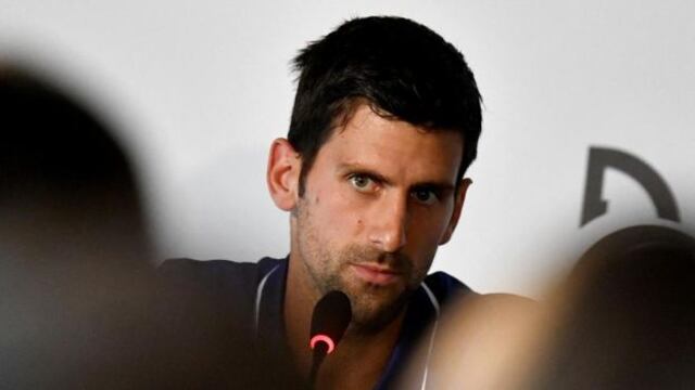 Djokovic apareció por la ventana del hotel donde permanece y realizó algunos gestos (VIDEO)