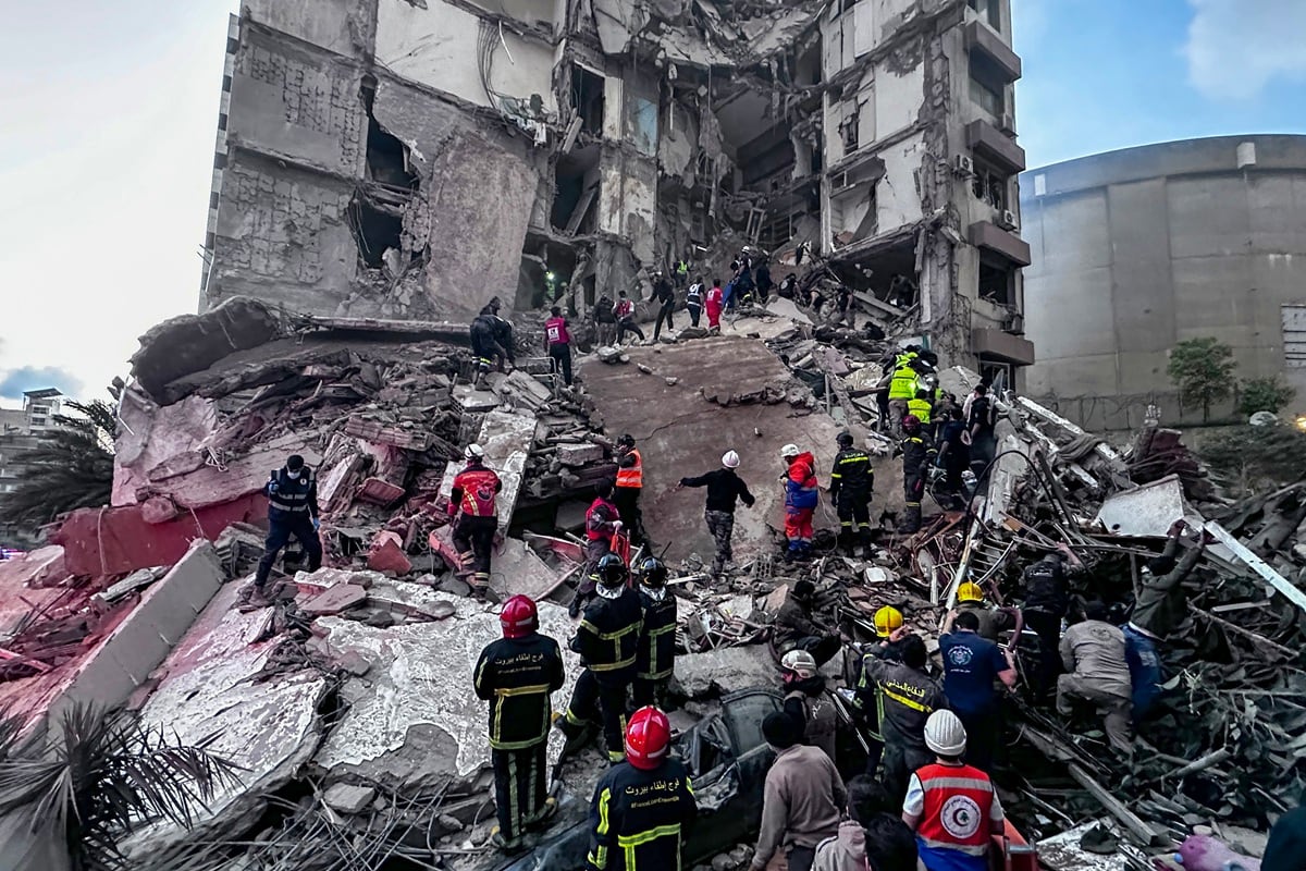 Equipos de rescate buscan a personas desaparecidas entre los escombros de un edificio residencial parcialmente destruido tras un ataque aéreo israelí, en el barrio de Tallet al-Khayat de Beirut, Líbano. (EFE/EPA/WAEL HAMZEH)