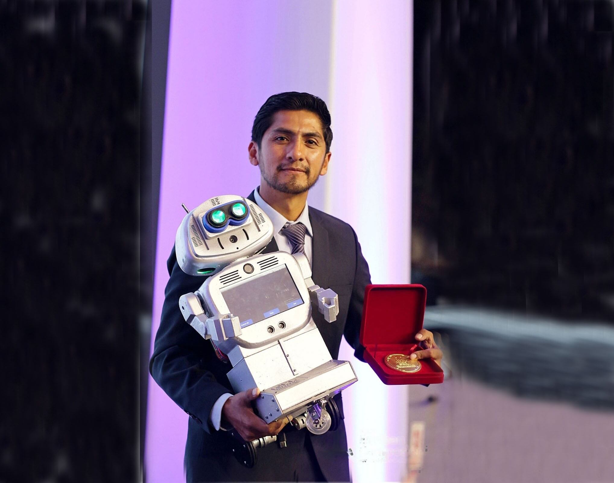 Con su robot Kipi y el premio Esteban Campodónico, el profesor Walter Velásquez.