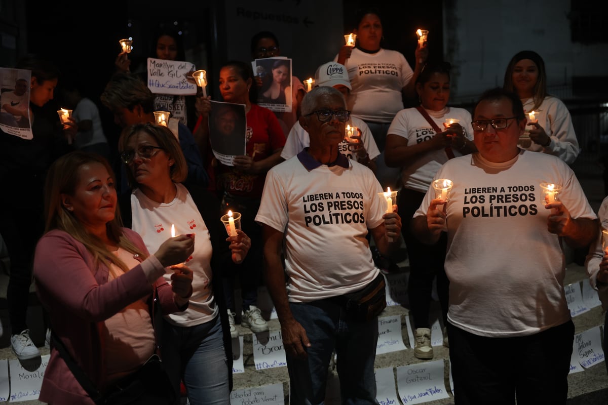 Familiares de presos políticos en Venezuela sostienen velas en una vigilia este sábado, afuera de El Helicoide en Caracas (Venezuela). Foto: EFE/ Miguel Gutiérrez