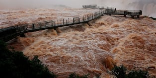 La pasarela para visitantes en las Cataratas del Iguazú sobre una fuerte corriente, en la triple frontera entre Brasil, Argentina y Paraguay, en la ciudad de Foz do Iguaçu, estado de Paraná, Brasil, el 13 de octubre de 2026. (CHRISTIAN RIZZI / AFP)