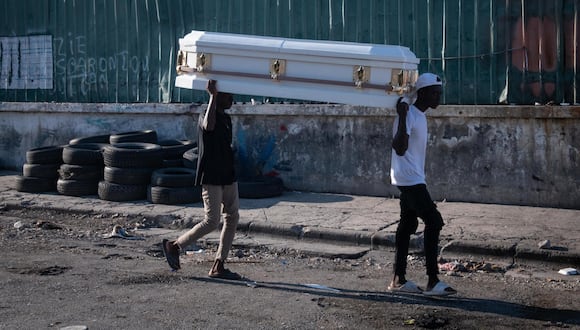 Dos hombres cargan un ataúd por una calle este sábado en Puerto Príncipe, capital de Haití. (EFE/ Johnson Sabin).