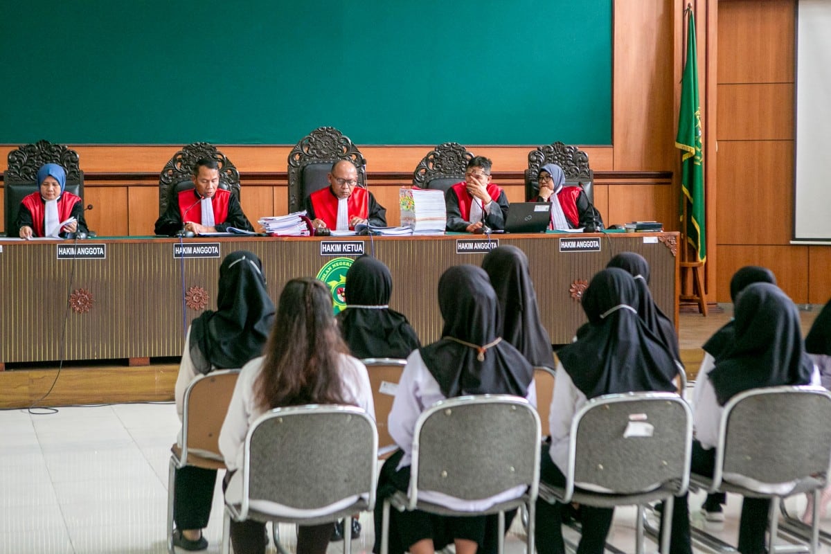 Defendants, accused of child abuse at the Little Aresha Daycare, attend their trial session before a panel of judges at the Yogyakarta District Court in Yogyakarta on October 28, 2026. An Indonesian court on October 28, sentenced 11 childcare workers to up to three years in prison for abusing toddlers at a daycare centre in a case that sparked nationwide outrage. (Photo by DEVI RAHMAN / AFP)