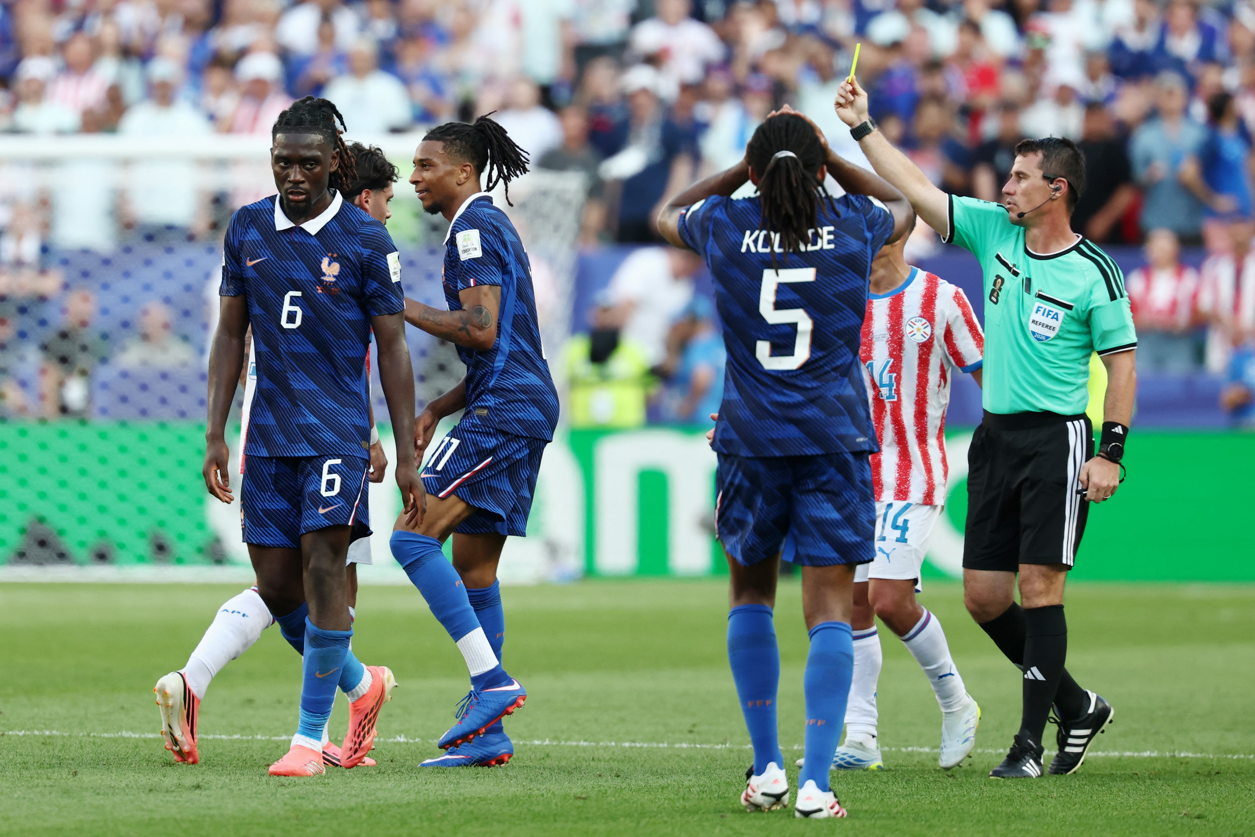 Uzbek referee Ilgiz Tantashev shows a yellow card to France's forward #11 Michael Olise during the 2026 World Cup round of 16 football match between Paraguay and France at the Philadelphia Stadium in Philadelphia on July 4, 2026. (Photo by FRANCK FIFE / AFP)