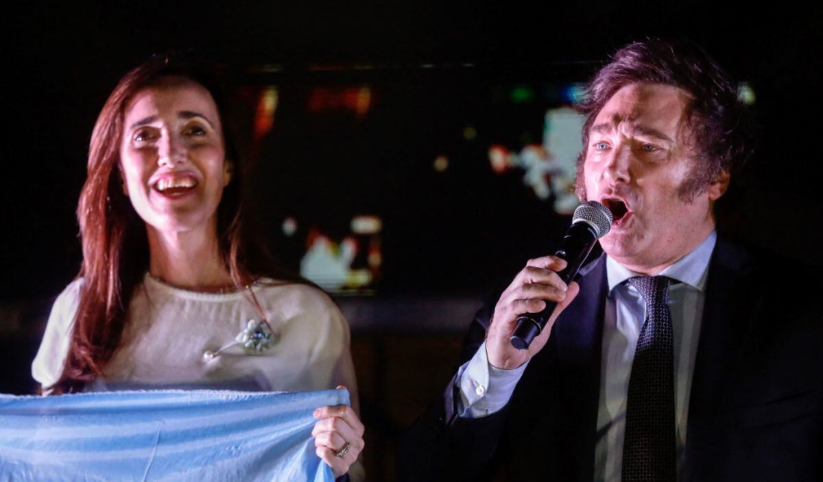 El candidato presidencial argentino por la alianza La Libertad Avanza, Javier Milei (R), habla con sus seguidores, acompañado por su compañera de fórmula Victoria Villarruel, después de ganar la segunda vuelta de las elecciones presidenciales frente a la sede de su partido en Buenos Aires el 19 de noviembre de 2023 | Foto: EMILIANO LASALVIA / AFP