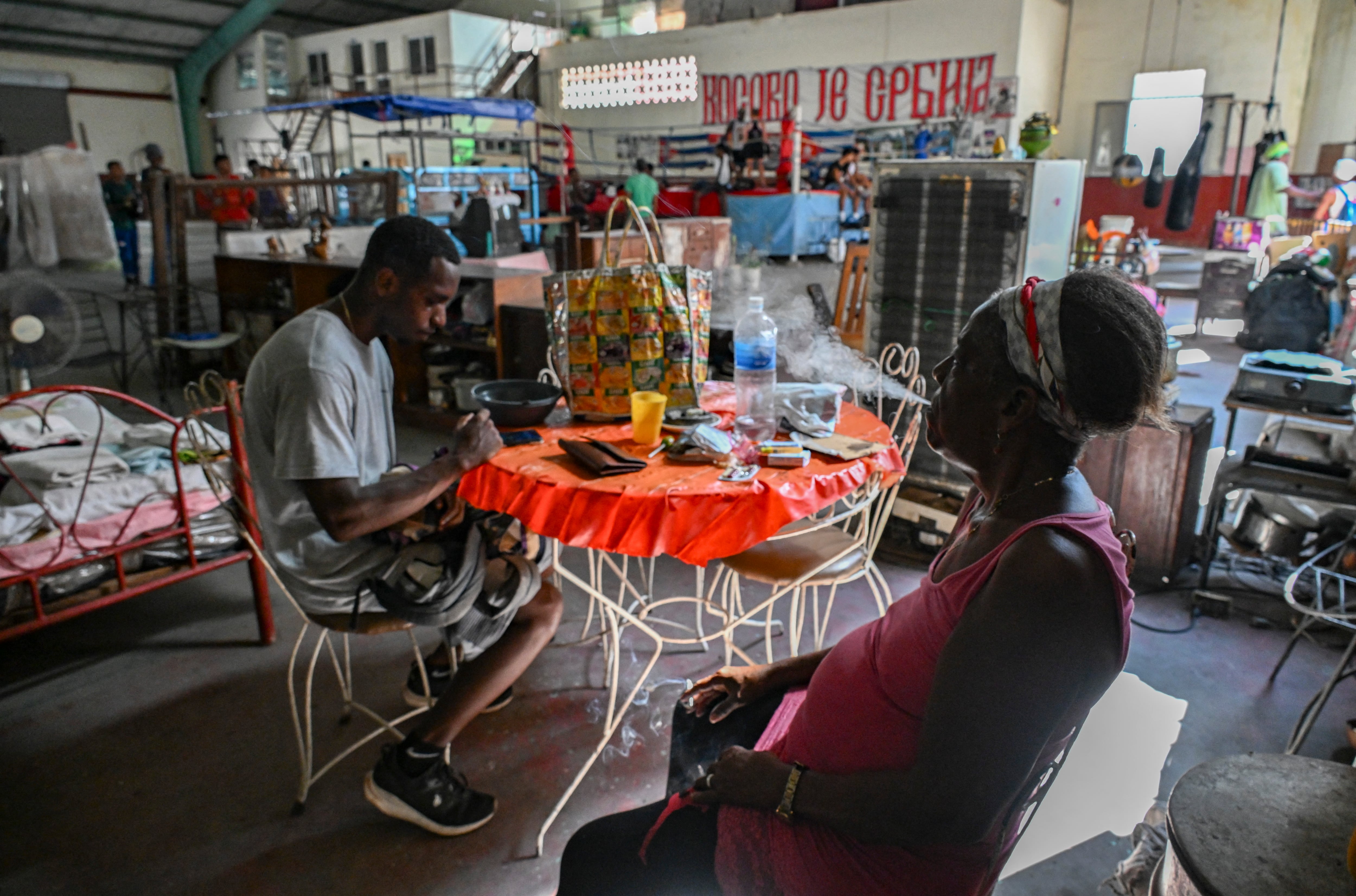 Lo que iba a ser una solución temporal de 15 días se ha prolongado durante casi tres años. Entre sacos de boxeo, cartones y divisiones improvisadas, familias enteras esperan una vivienda en medio de la crisis que atraviesa Cuba. (Photo by YAMIL LAGE / AFP)