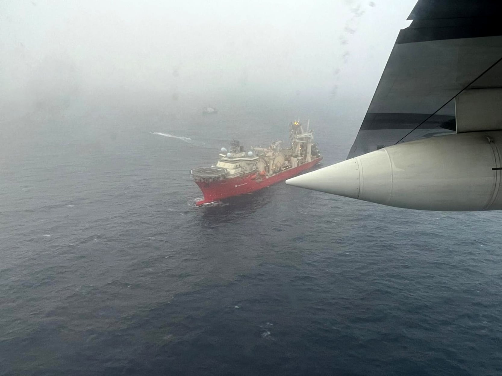 En esta imagen aérea del 20 de junio de 2023 obtenida de la Guardia Costera de EE. UU., el barco Deep Energy navega en el área de búsqueda del sumergible Titan de OceanGate. (Photo by Handout/US Coast Guard/AFP)