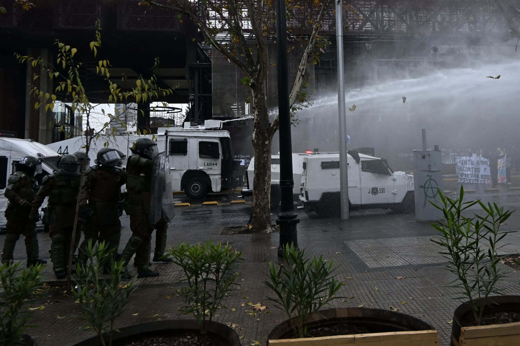 Police throw water at demonstrators during a students march against social cuts pushed through by Chile's President Jose Antonio Kast in Santiago, on June 3, 2026. (Photo by RODRIGO ARANGUA / AFP)